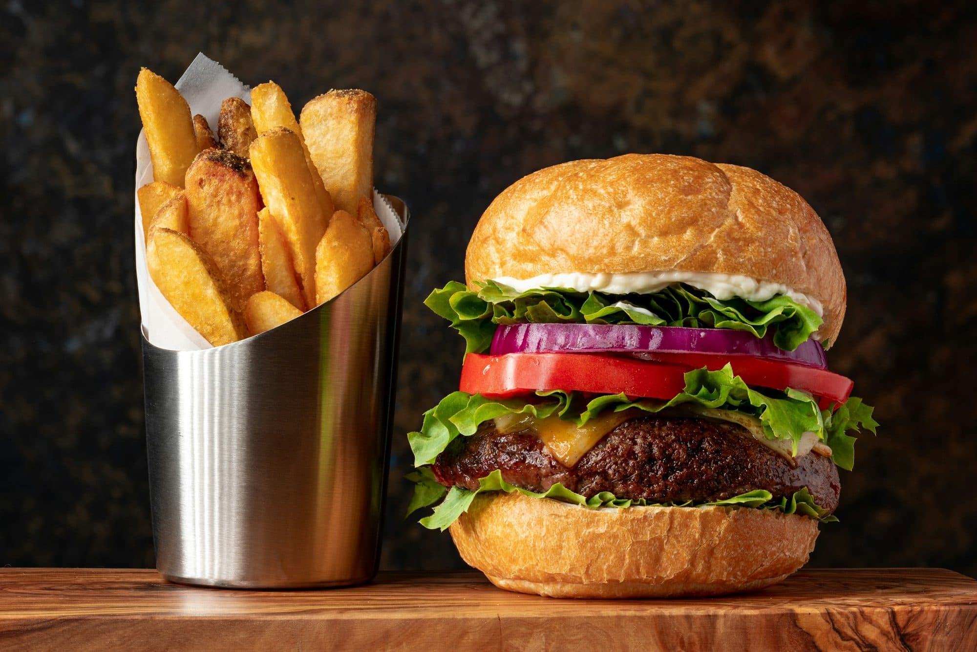 Ahşap tezgâhta smash burger ve patates kızartması